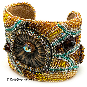 Inspired by a Bee Cuff by Rose Rushbrooke. Bead embroidery. Glass seed beads, polymer clay focal, and crystals. Image copyright © Rose Rushbrooke.