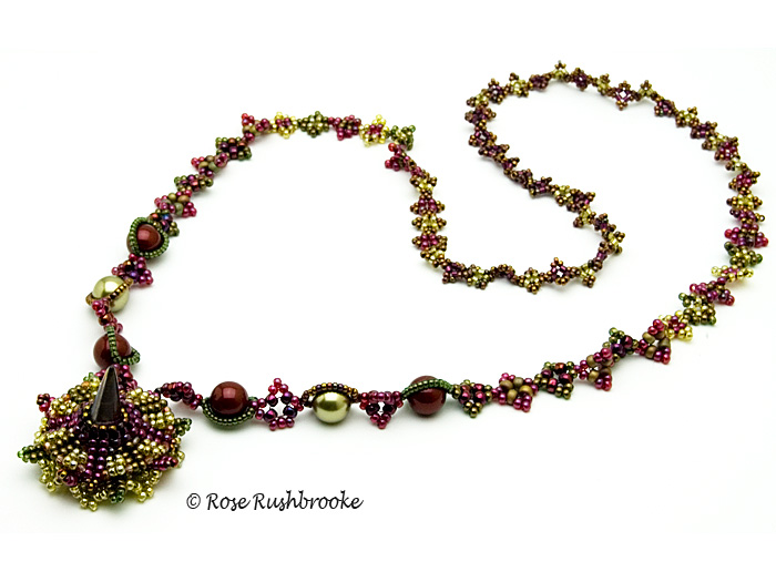 Opened snap clasp of burgundy and olive necklace by Rose C Rushbrooke. Beadweaving - glass spike bead, Swarovski crystals and pearls, and seed beads. Image copyright &copy; Rose Rushbrooke.
