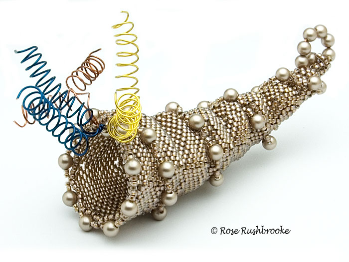 Horn of Plenty basket - beadweaving. Made with seed beads, drops, fire polish crystals, and Swarovski rivolis. Image copyright &copy; Rose C Rushbrooke.
