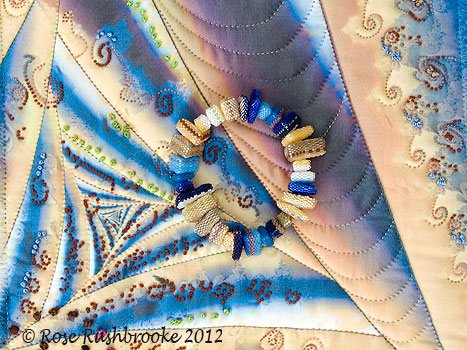 Bangle shown laying on the fractal art quilt Rabbit Hole. Image copyright &copy; Rose Rushbrooke.