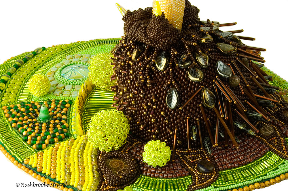 Close up 1 of Triffid - seed beads, crystals, Czech glass beads, ceramic focal, ammonites, and selected beads. Peyote stitch beadweaving, bead embroidery. BeadDreams 2018 finalist. Image copyright © Rose Rushbrooke.