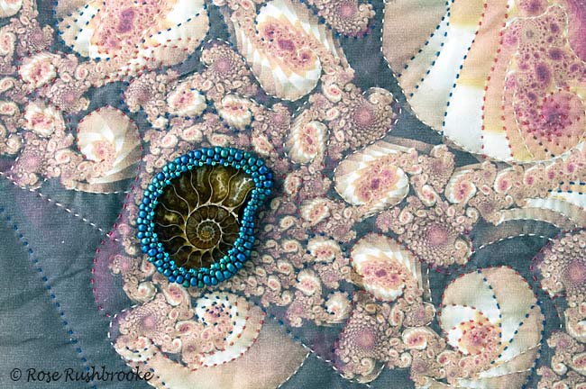 Close up of a beaded ammonite stitched onto fabric using peyote stitch and seed beads. Image copyright &copy; Rose Rushbrooke.